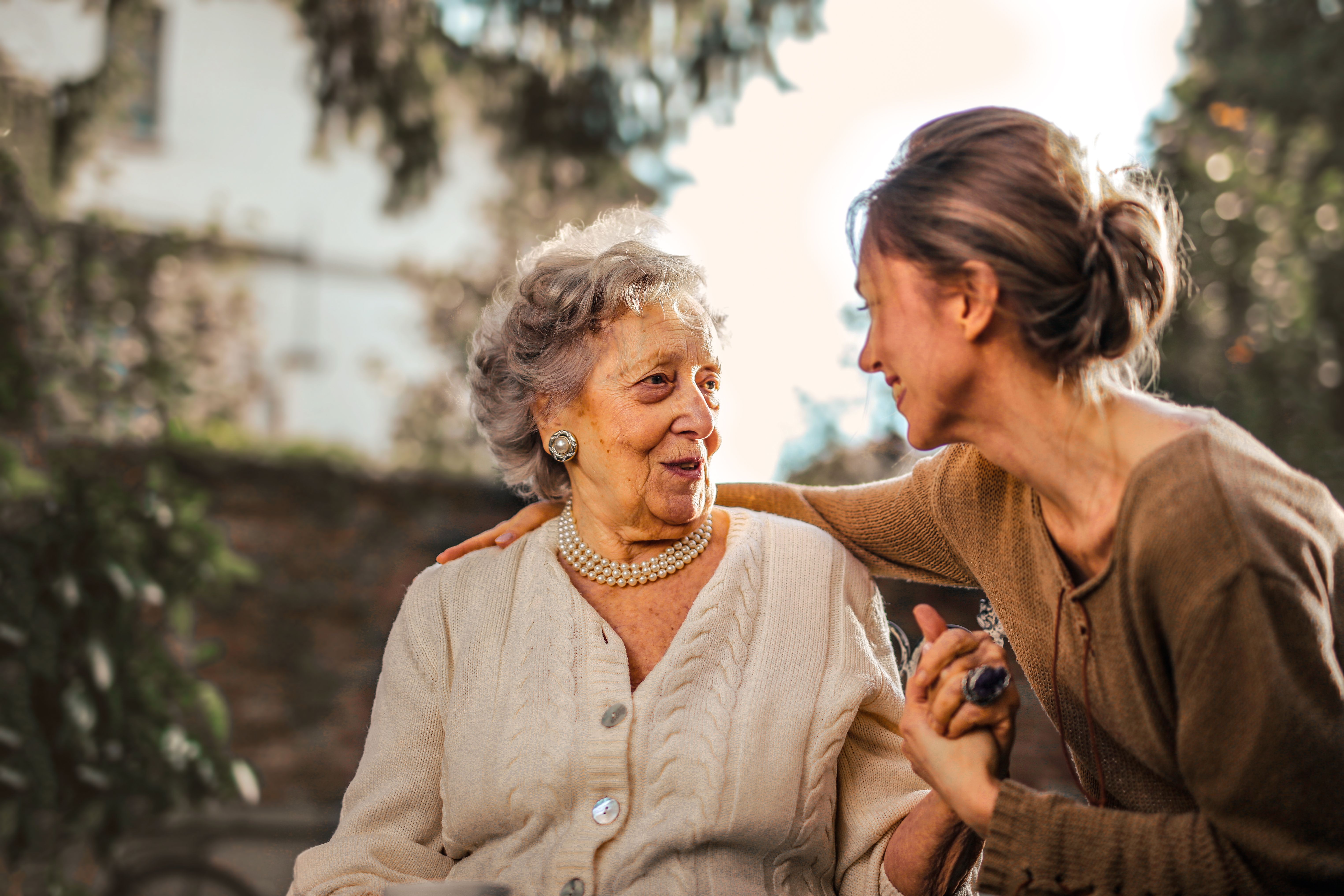 A trusted companion and older woman in warm, genuine conversation